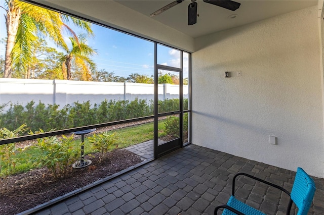 unfurnished sunroom with ceiling fan