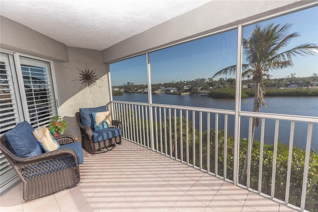 sunroom featuring a water view