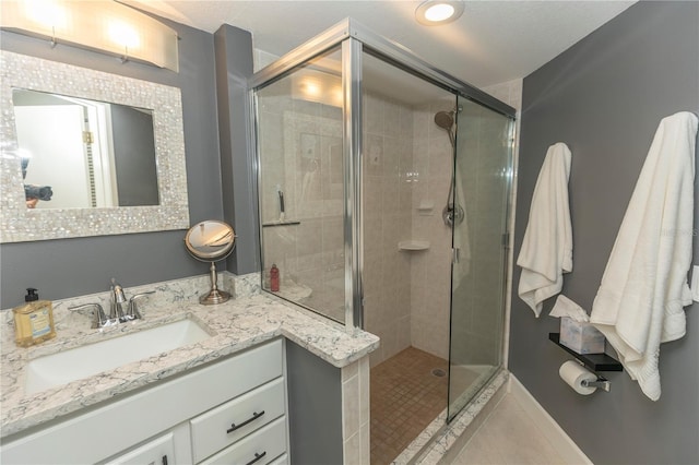 bathroom with tile patterned floors, vanity, and walk in shower