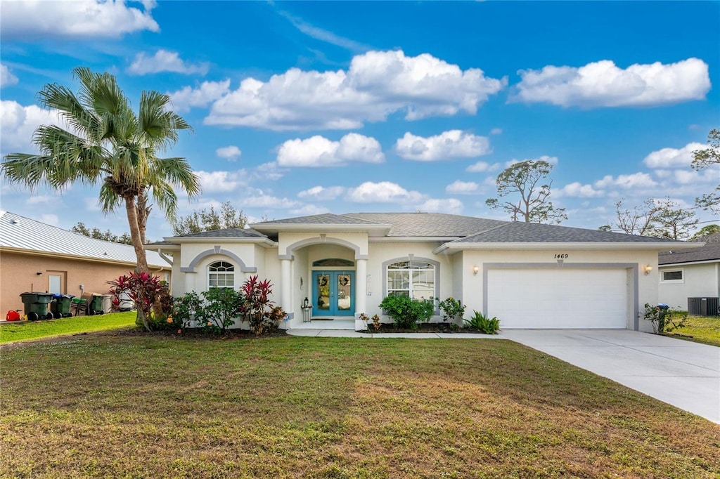 view of front facade with a front yard, french doors, and a garage