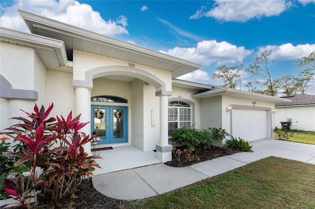 view of exterior entry featuring french doors and a garage