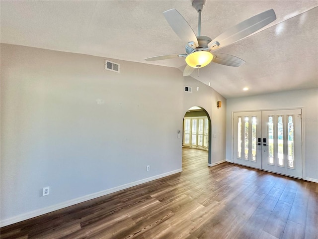 empty room featuring hardwood / wood-style floors, a textured ceiling, ceiling fan, and lofted ceiling