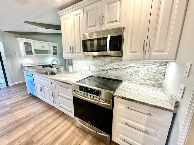 kitchen featuring sink, light wood-type flooring, appliances with stainless steel finishes, tasteful backsplash, and white cabinetry