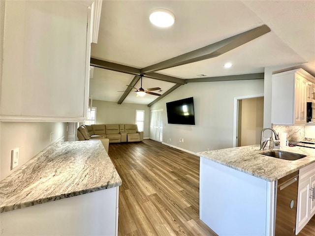 kitchen featuring lofted ceiling with beams, white cabinetry, light stone countertops, and light hardwood / wood-style floors