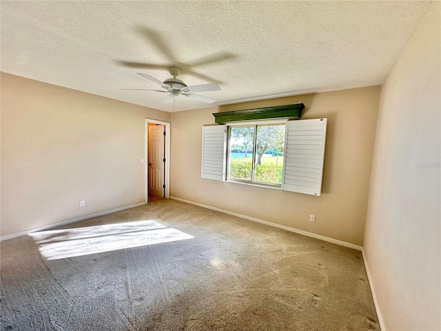 unfurnished room with ceiling fan, carpet floors, and a textured ceiling