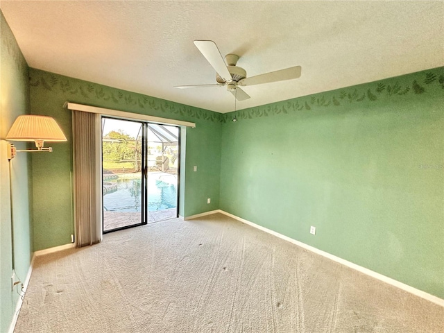 unfurnished room featuring a textured ceiling, ceiling fan, and light carpet