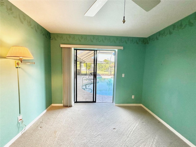 spare room featuring carpet and ceiling fan