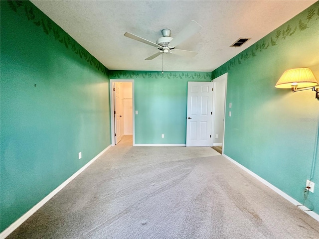 carpeted spare room with a textured ceiling and ceiling fan