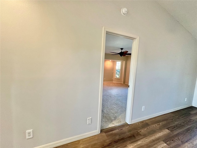 empty room featuring dark hardwood / wood-style floors, ceiling fan, and vaulted ceiling