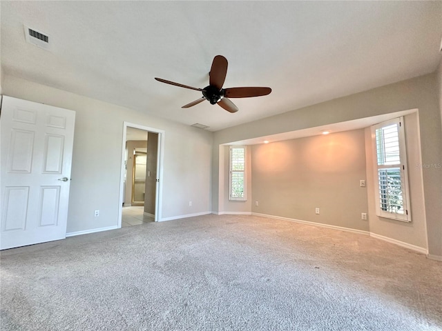 carpeted empty room featuring plenty of natural light and ceiling fan