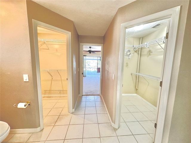 bathroom with toilet, a textured ceiling, tile patterned floors, and ceiling fan