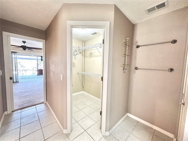 bathroom with ceiling fan, tile patterned flooring, and a textured ceiling