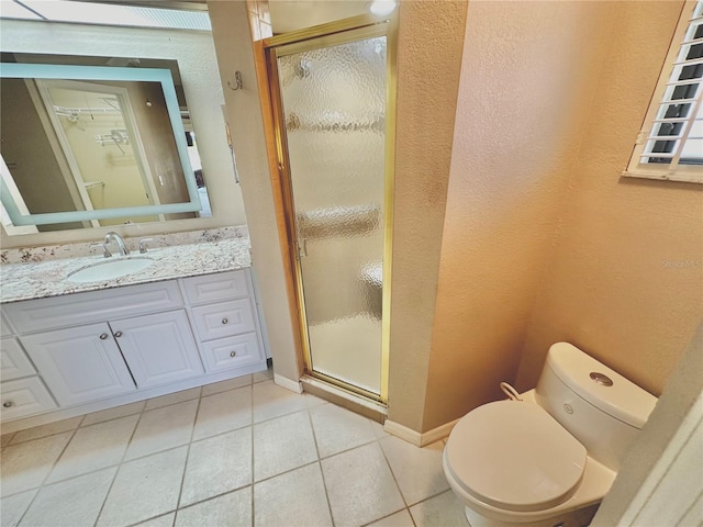 bathroom featuring toilet, tile patterned flooring, vanity, and walk in shower