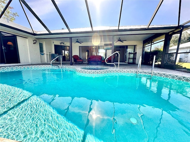 view of pool with glass enclosure, ceiling fan, and a patio area