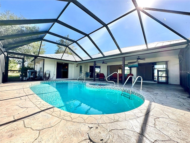 view of pool featuring a patio, glass enclosure, and ceiling fan