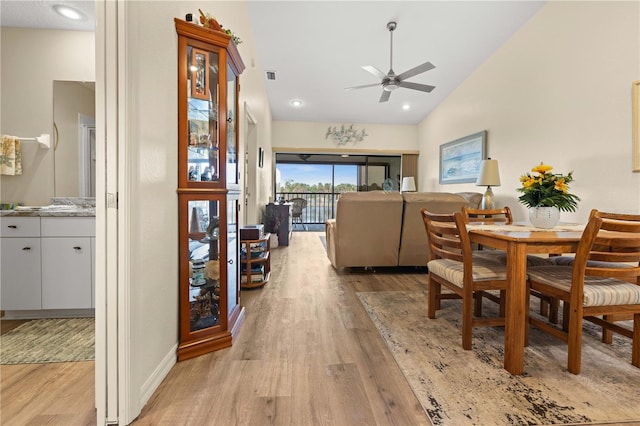 dining space with light hardwood / wood-style floors, vaulted ceiling, and ceiling fan