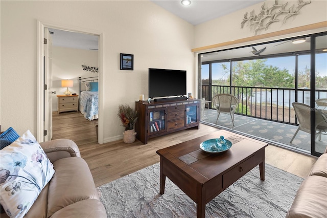 living room with ceiling fan and light wood-type flooring