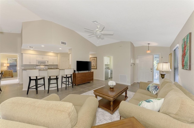 living room with light tile patterned floors, ceiling fan, lofted ceiling, and sink