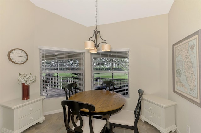 dining area featuring light tile patterned floors and an inviting chandelier