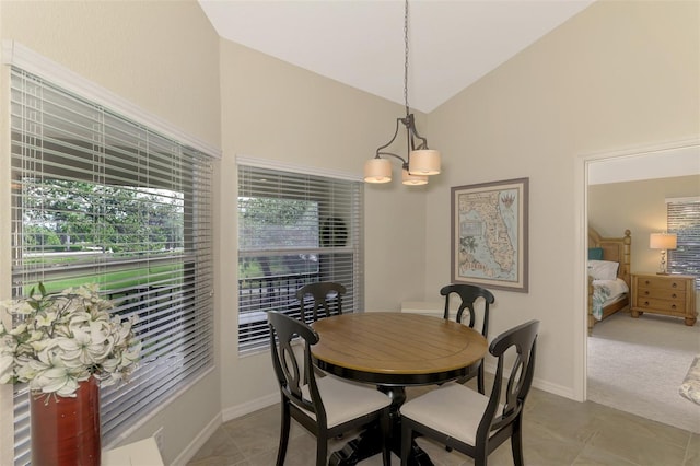 dining room with a chandelier, light tile patterned floors, and vaulted ceiling