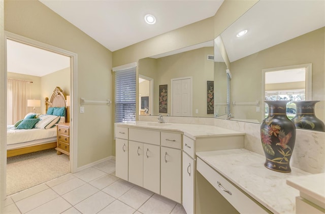 bathroom featuring tile patterned flooring, vanity, and lofted ceiling