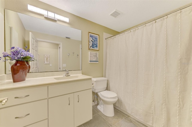 bathroom featuring tile patterned floors, vanity, toilet, and a textured ceiling