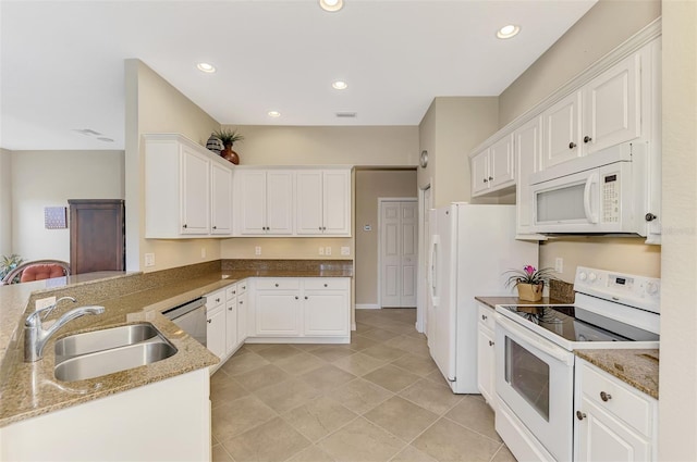 kitchen featuring white appliances, sink, stone countertops, white cabinetry, and kitchen peninsula