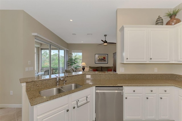 kitchen with kitchen peninsula, white cabinets, dark stone counters, sink, and dishwasher