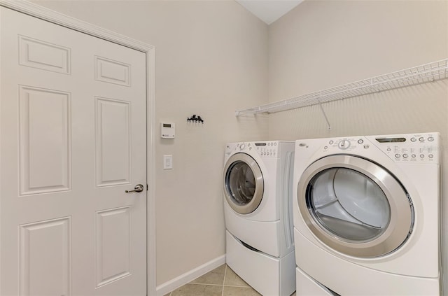 washroom featuring light tile patterned flooring and washing machine and clothes dryer