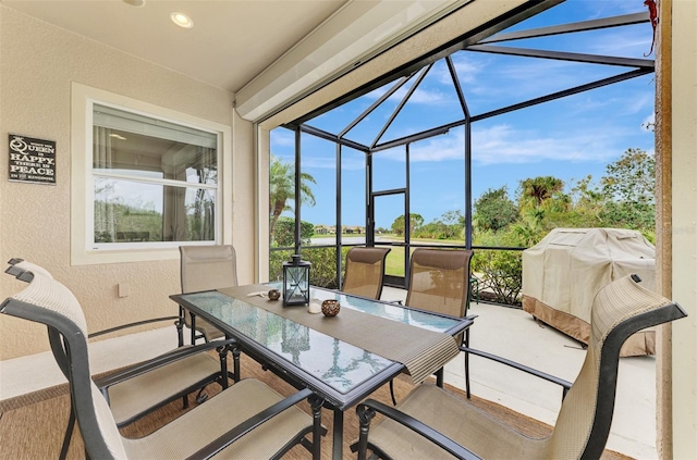 view of patio with area for grilling and a lanai