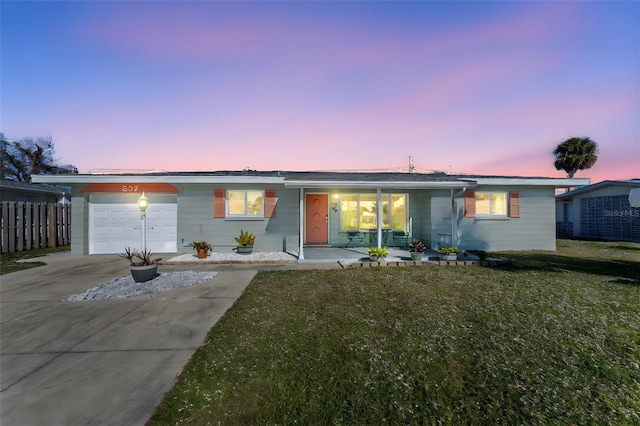 ranch-style house with concrete driveway, an attached garage, fence, a front lawn, and a porch