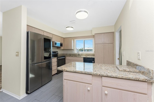 kitchen with light brown cabinetry, appliances with stainless steel finishes, a peninsula, and a sink