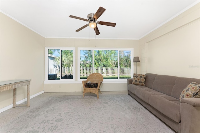 carpeted living area with baseboards, a ceiling fan, and crown molding