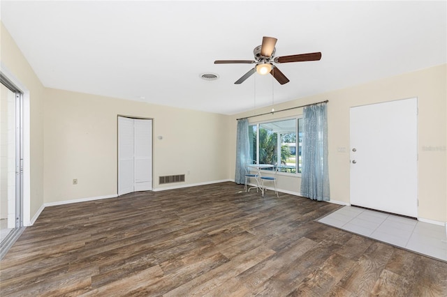 interior space featuring a ceiling fan, wood finished floors, visible vents, and baseboards