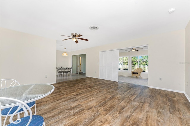 living area featuring baseboards, visible vents, and wood finished floors