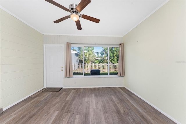 empty room featuring ornamental molding, ceiling fan, baseboards, and wood finished floors