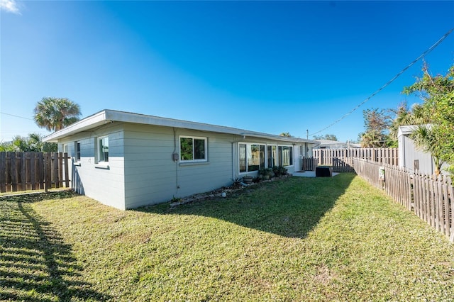 back of property featuring a fenced backyard and a yard