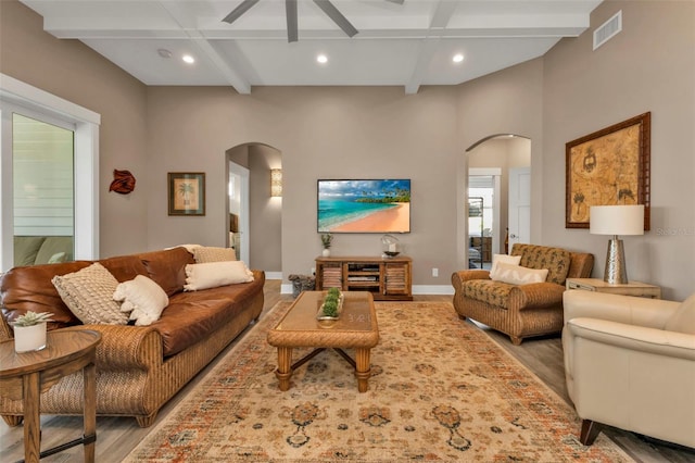 living room with arched walkways, recessed lighting, visible vents, beamed ceiling, and baseboards