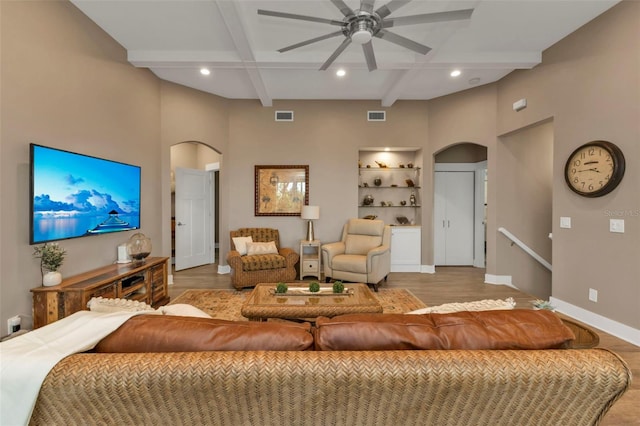 living area with arched walkways, visible vents, and baseboards