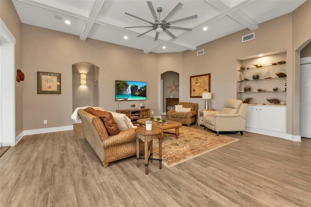 living area featuring light wood-type flooring, visible vents, and arched walkways