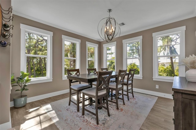 dining room featuring a chandelier, ornamental molding, and light wood-style flooring