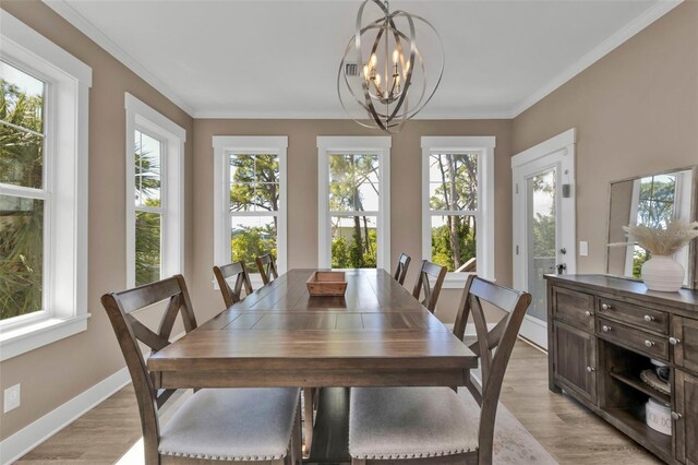 dining room featuring an inviting chandelier, light wood-style flooring, ornamental molding, and baseboards