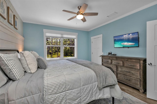 bedroom with ornamental molding, wood finished floors, and a ceiling fan