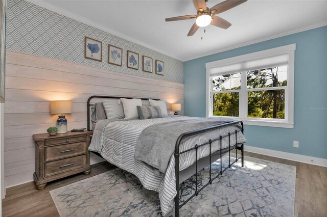 bedroom featuring ornamental molding, wood finished floors, and baseboards