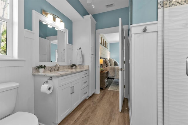 bathroom with visible vents, toilet, ensuite bathroom, vanity, and wood finished floors