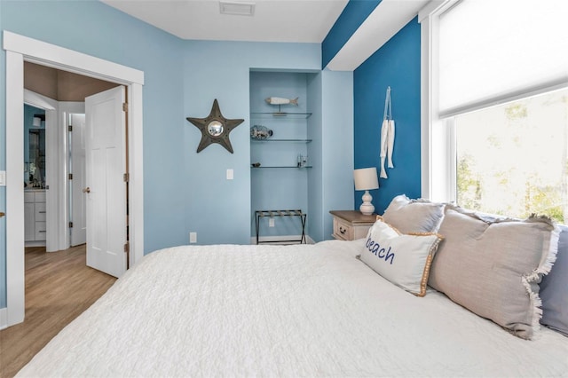 bedroom featuring light wood-style flooring and visible vents