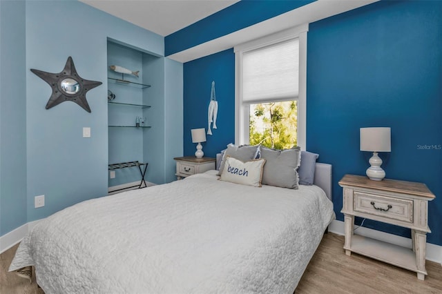 bedroom featuring light wood-type flooring and baseboards