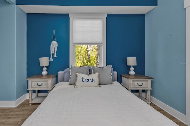 bedroom featuring dark wood-style floors and baseboards