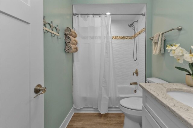 full bath with toilet, vanity, shower / bath combination with curtain, and wood finished floors