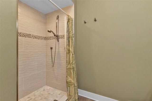 bathroom featuring a stall shower and baseboards